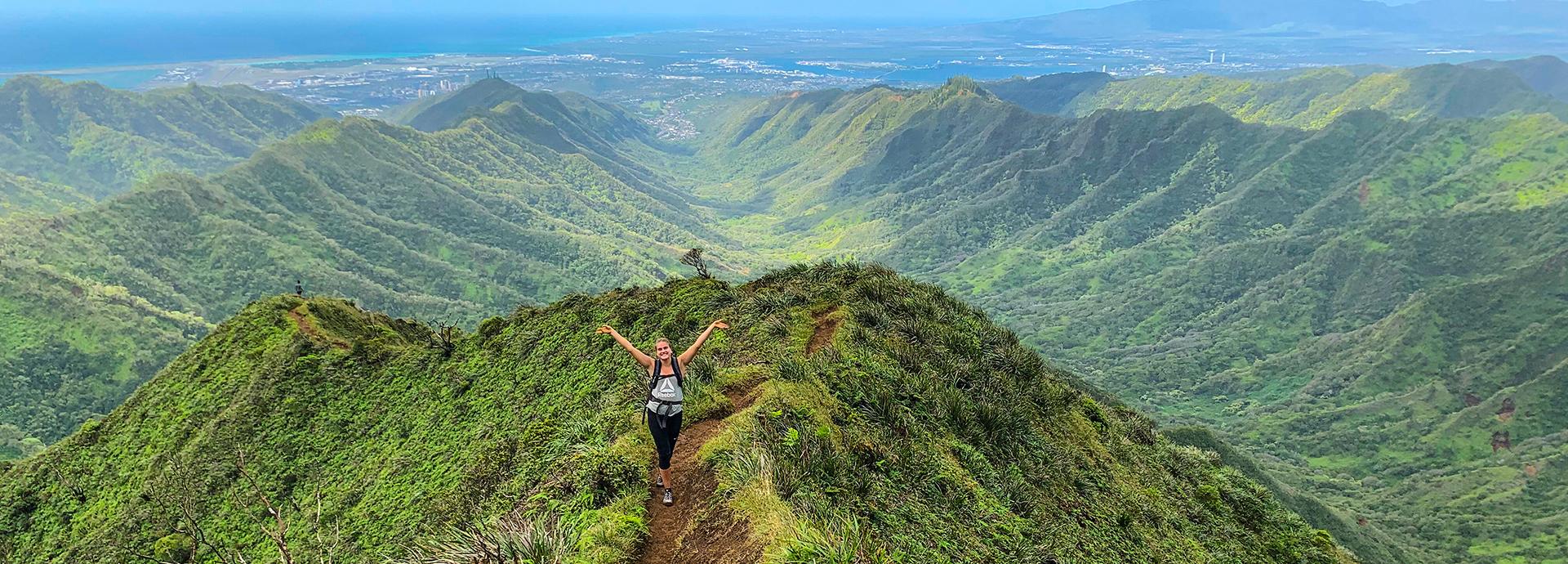 Fulbright Finland Undergraduate grantee Isa Lassinaro standing on a trail on a green mountain in Hawaii