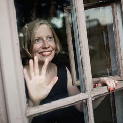 A portrait of Pirita Tolvanen, taken through a window.