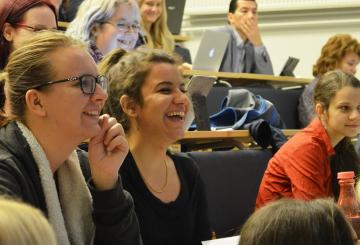 Students laughing in a full lecture hall