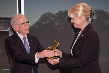IIE President Allan Goodman awarding Fulbright Finland Foundation CEO Terhi Mölsä the IIE Europe Award for Excellence, a green porcelain sculpture