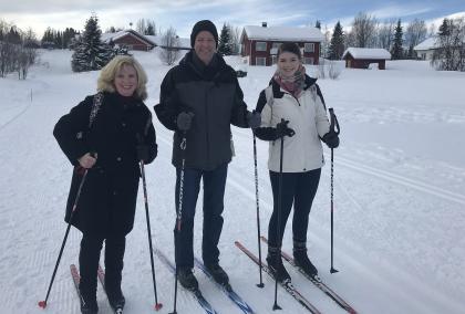 The Buchanan family on cross-country skiis at Ylläs, there is snow around them, and they are all smiling at the camera.