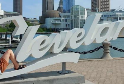 A woman sitting in the letter C in a Cleveland sign