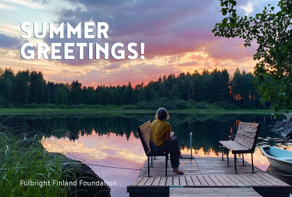 A person sitting on a chair on a pier during a summer evening. There is a forest behind the lake and the sky has colors of orange, blue, and purple. It says "Summer greetings!" on the upper left corner and Fulbright Finland Foundation on the lower left corner.
