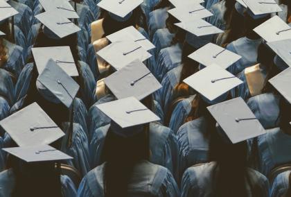 Many students wearing graduation caps in an audience