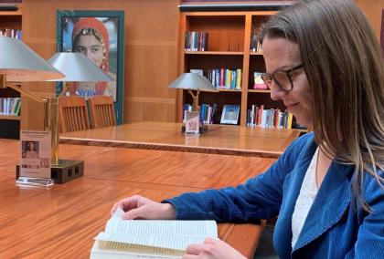 Mervi Kaukko reading a book in a library