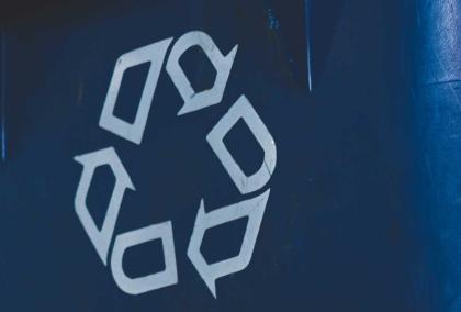 A recycle symbol on a blue trash bin