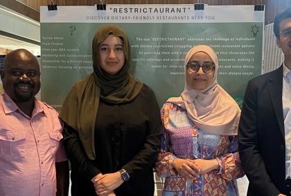 Salima Alaoui with three of her peers posing for a photograph. The group is at a restaurant.