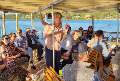 People on Steamboat Sabino at the Mystic River in Mystic, CT. In the middle of the photo there is a person telling something to the other people who are listening.