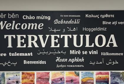 A sign of the word Welcome in different languages, with the biggest being the Finnish Tervetuloa