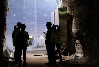 Members of the media examine the concrete back wall of a demonstration tunnel at Onkalo. They are standing in a disposal tunnel ~430 meters underground. Photo by Kate Thompson