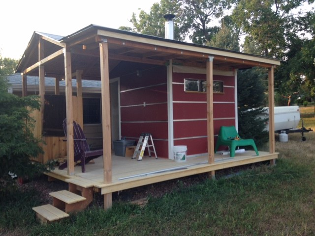 A red wooden sauna cabin on a yard.