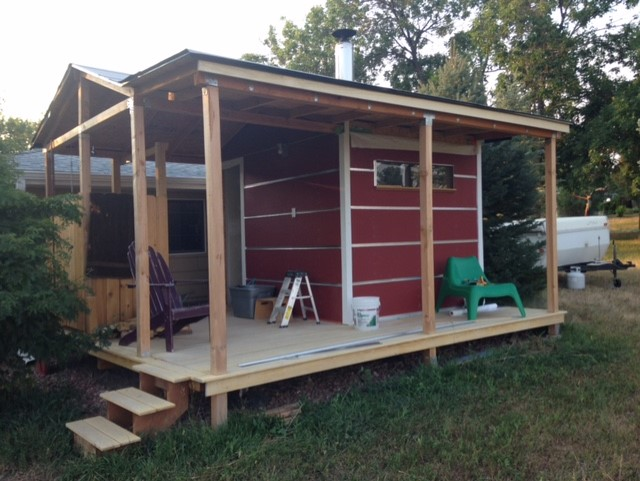 A red wooden sauna cabin on a yard. 