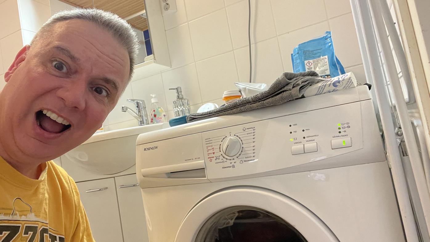 Adam Whaley-Connell looking frustrated next to a washing machine with different lights on
