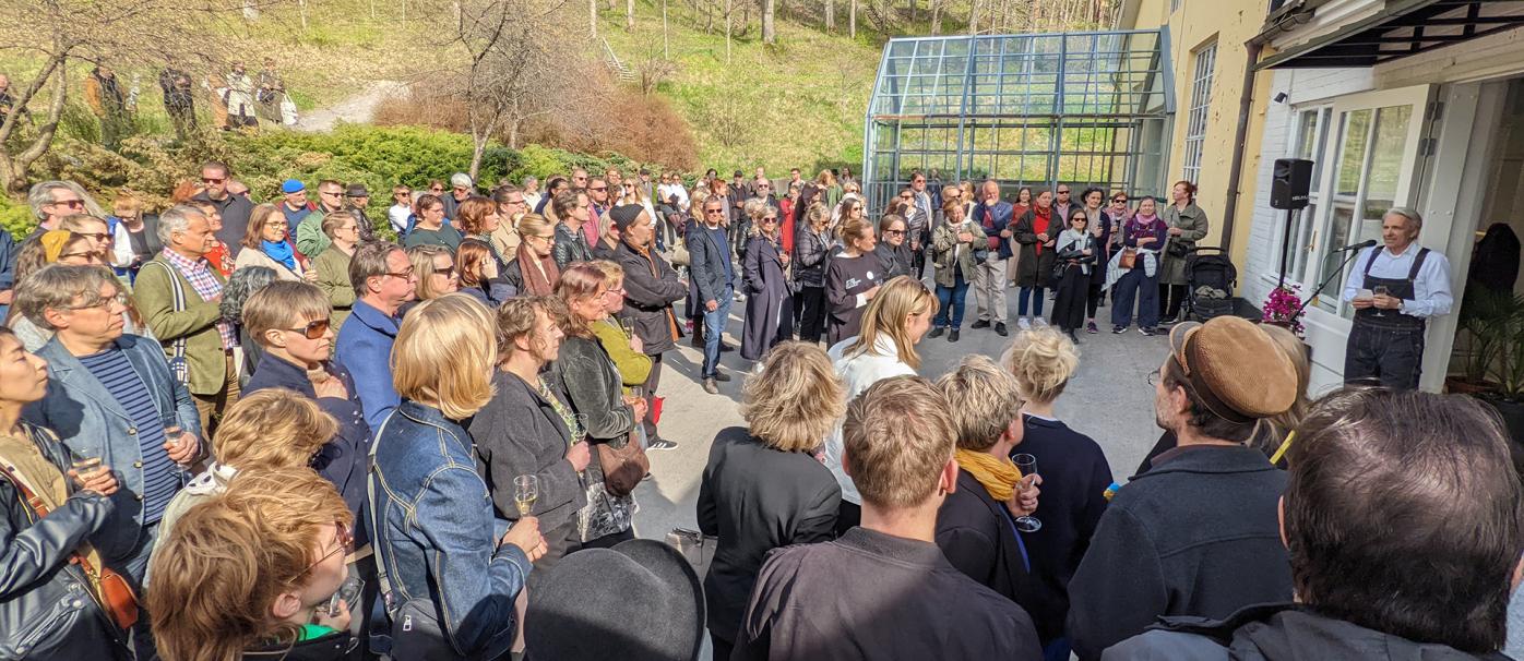 Crowd of people listening to a man talking during an opening ceremony of the Hidden exhibition at Fiskars