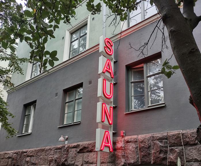 Neon red sign saying sauna on a wall of a building in Helsinki
