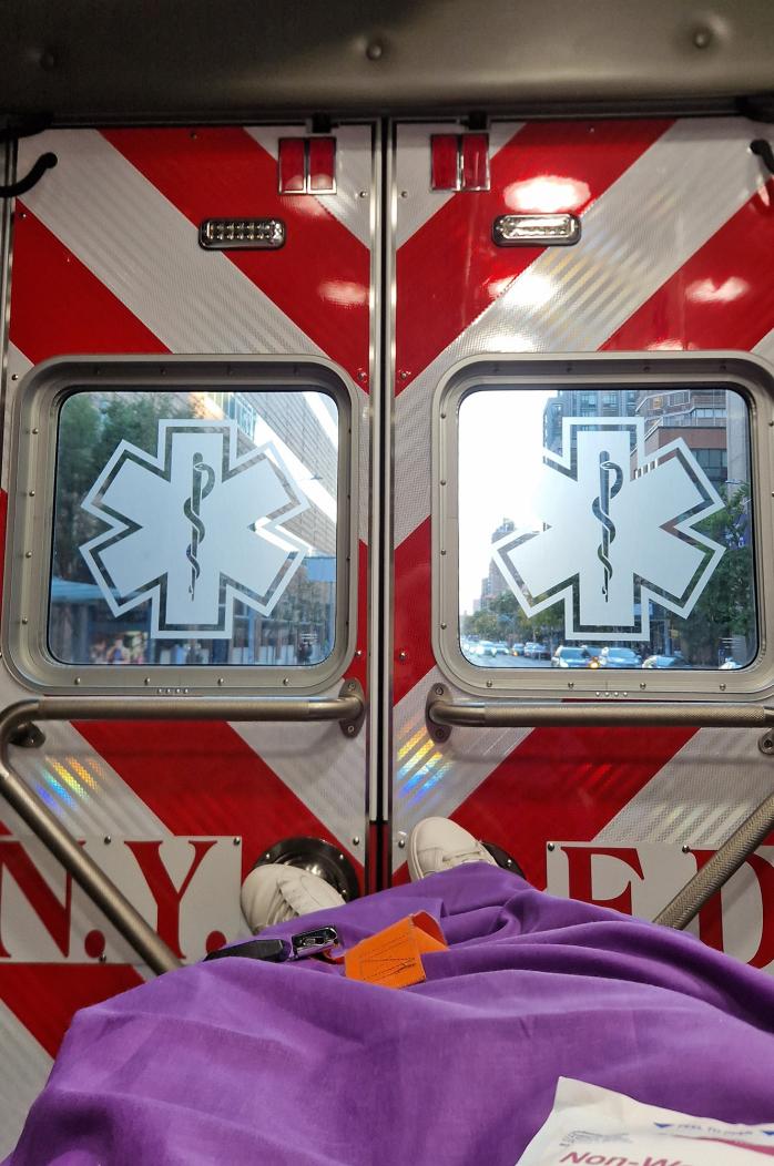 Photo from inside of an ambulance, showing the patients legs and the back doors of the ambulance