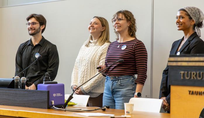 Four Fulbright Finland graduate students laughing during a presentation