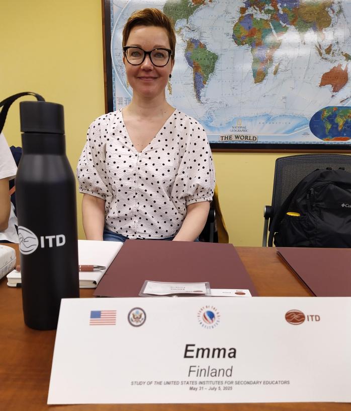 Person in a white shirt in front of a world map