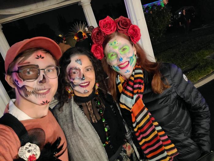 Three people in Dia de los muertos themed face paint