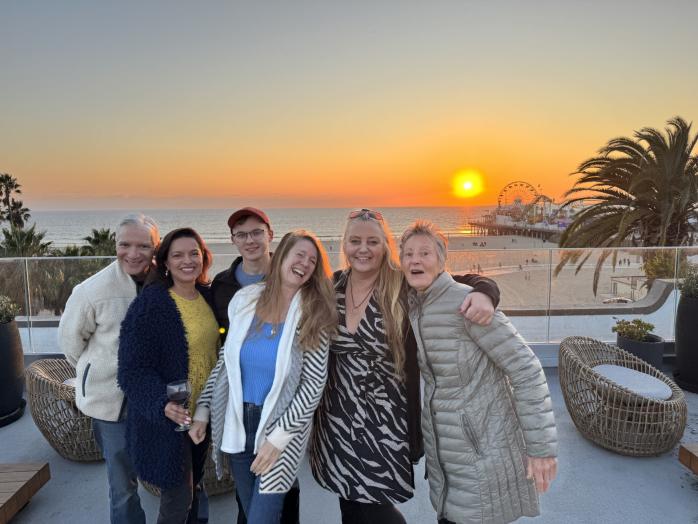 Group of people smiling at the camera during a sunset