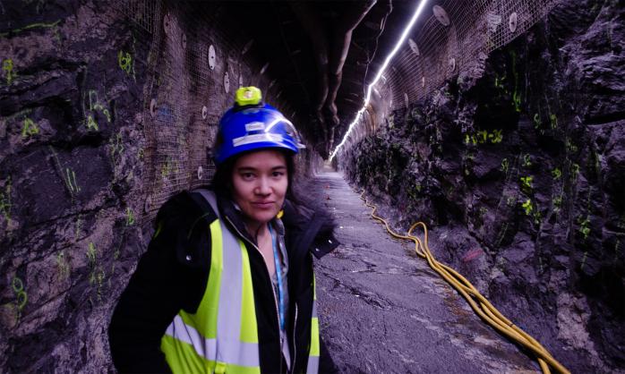Kate Thompson wearing a high visibility vest while being in a dark tunnel