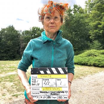 Victoria Schultz holding a clapperboard.