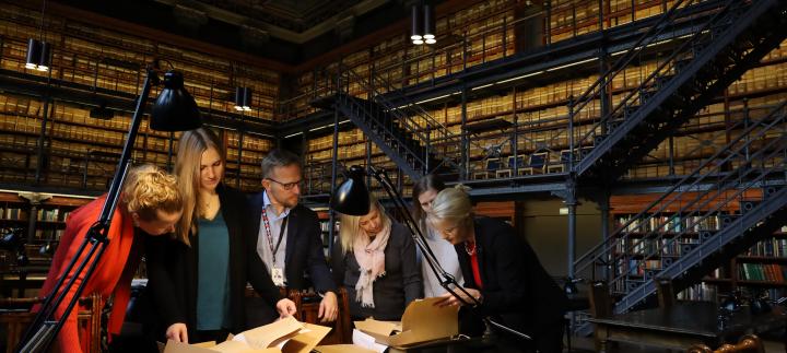 Fulbright Finland team members with Administrative Director Immo Aakkula going through the Foundation's archives in the reading room at the National Archives of Finland