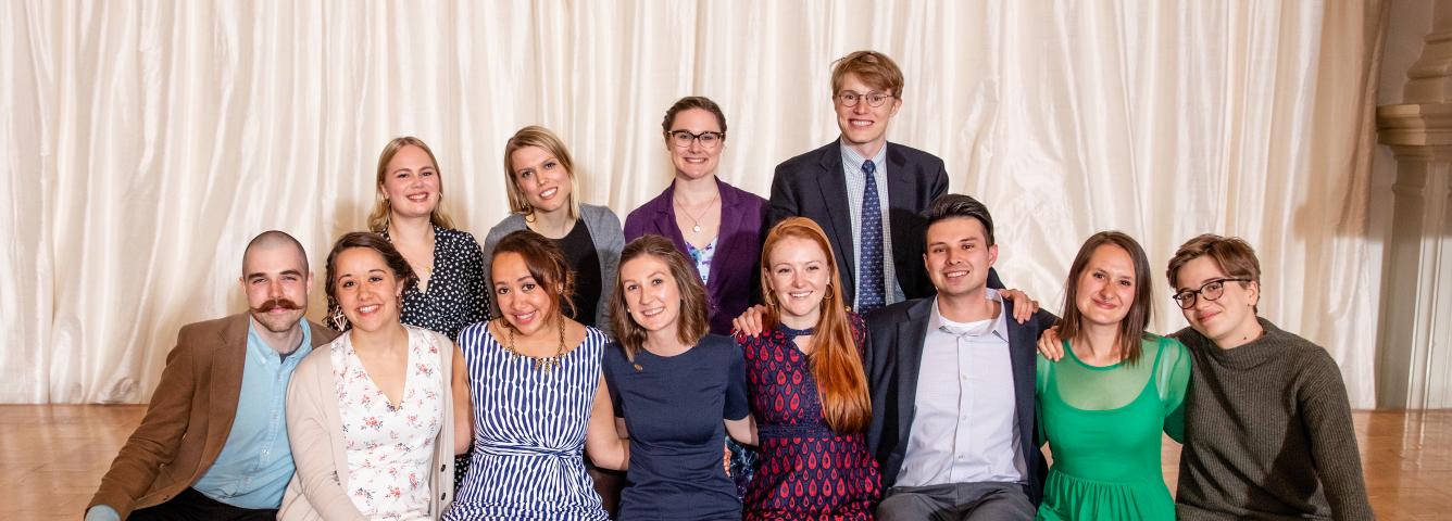 2018-2019 U.S. Fulbright Fellows sitting in two rows and hugging each other, smiling at the camera at the Helsinki City Hall after 2019 Fulbright Award Ceremony
