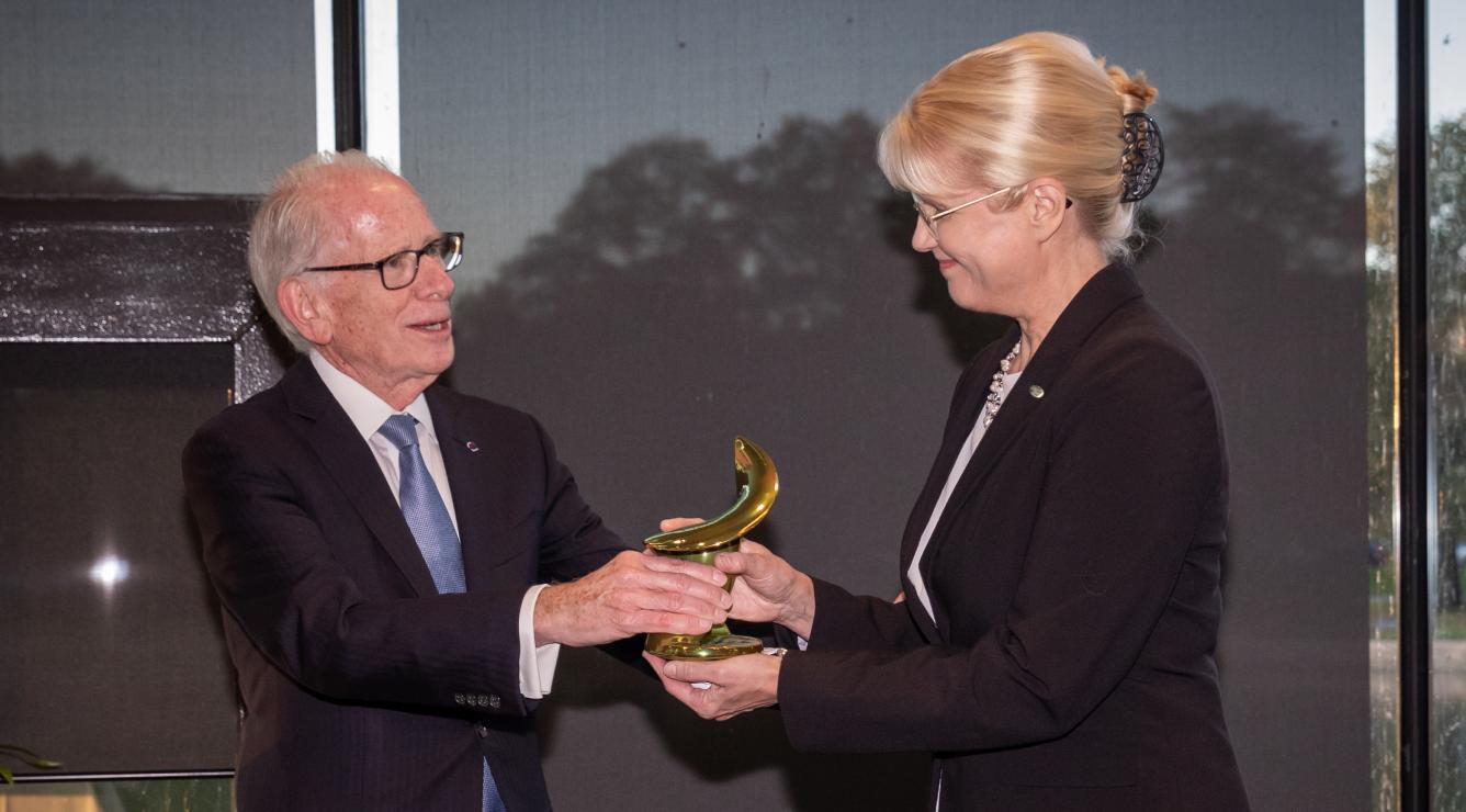 IIE President Allan Goodman awarding Fulbright Finland Foundation CEO Terhi Mölsä the IIE Europe Award for Excellence, a green porcelain sculpture