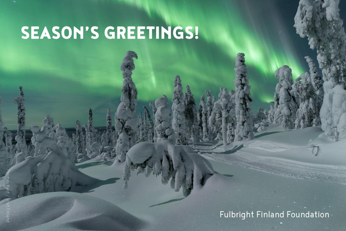 Green aurora borealis in the background with snowy trees in the front. "Season's Greetings!" written on the upper left corner, Fulbright Finland Foundation in the lower right corner. The photo is credited Thomas Kast / Visit Finland.