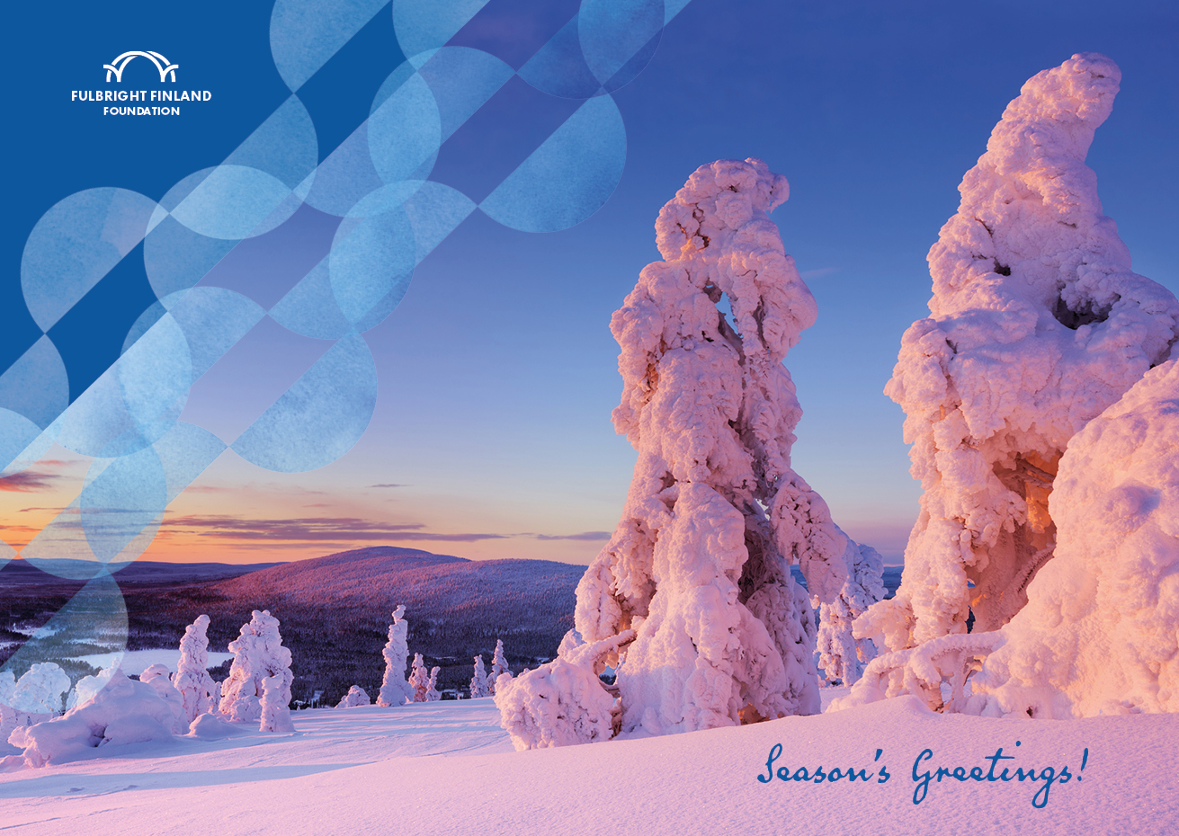 A wintery view, taken in Lapland, Finland. There is a lot of snow on trees, and a fell can be seen in the background. Sun is shining from low, coloring the photo in reds and yellows. There is a Fulbright Finland Foundation logo on the right and it says "Season's Greetings!" on the bottom.