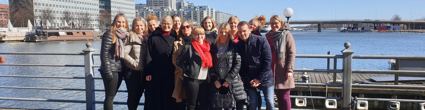 Fulbright Finland team standing in front of the office building on a sunny day