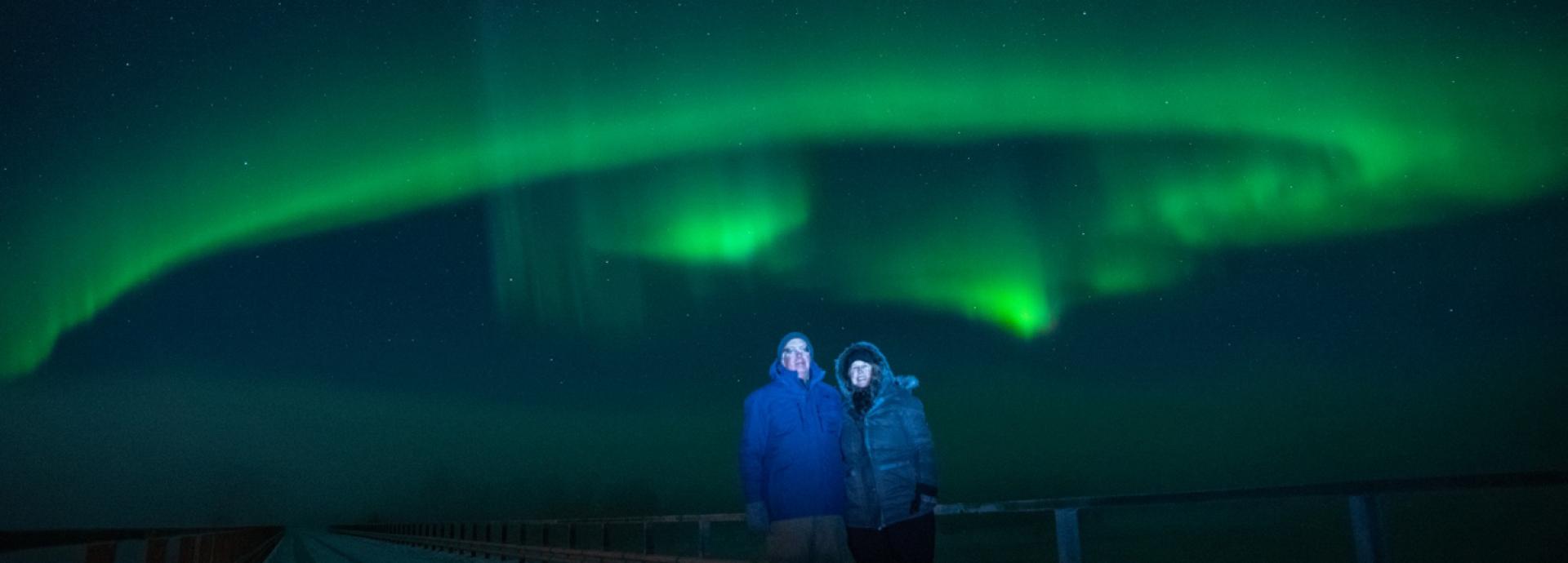 David Dorman and his wife Melanie standing in front of green Northern Lights