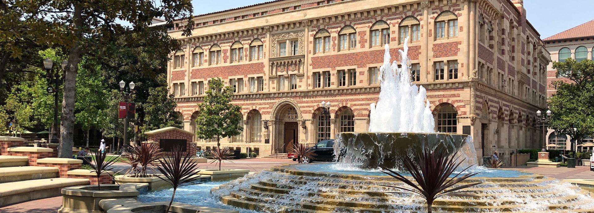 Photo of University of Southern California campus with a university building and water fountain.