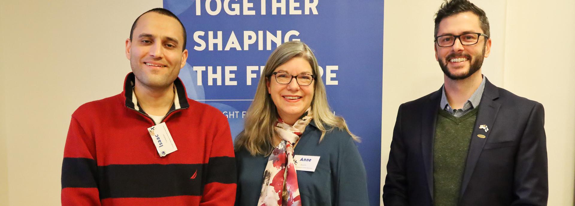 Isaac Farhadian, Anne Boyette, and Ryan Lewis in front of the Fulbright Finland Foundation's roll-up.