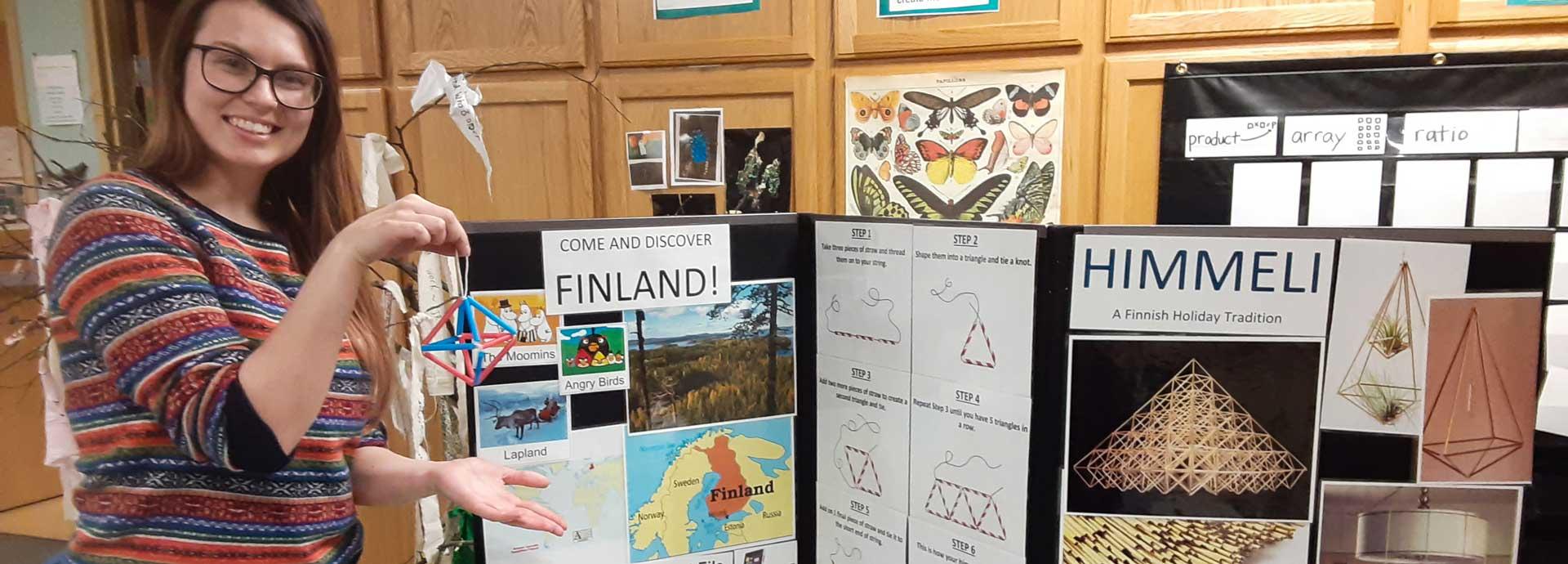 Fulbright Finland grantee Sanni Törmänen with posters and information about Finland at an international fair