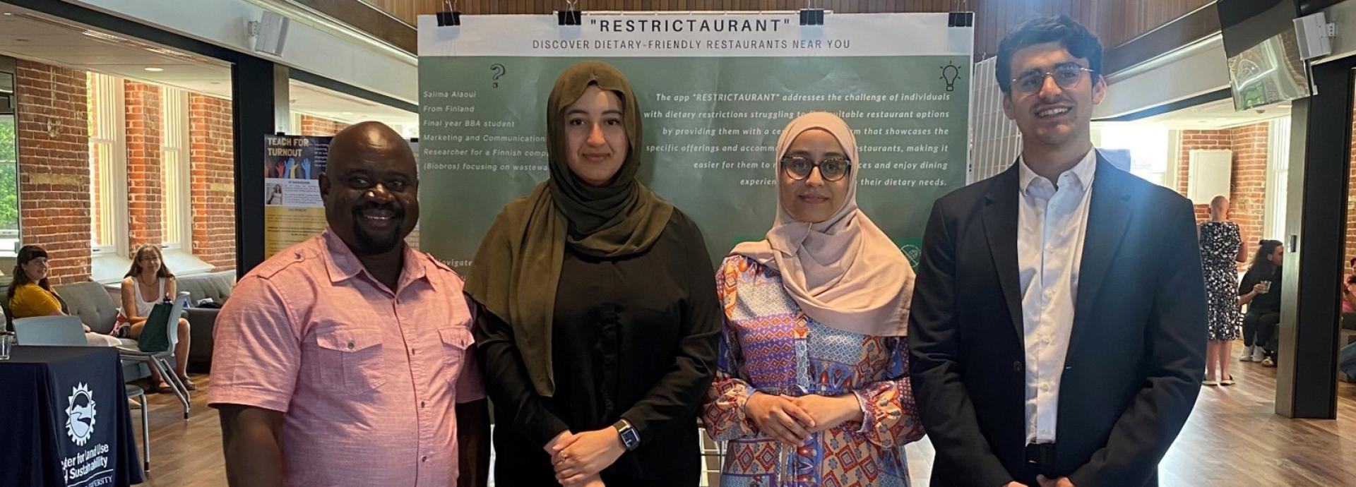Salima Alaoui with three of her peers posing for a photograph. The group is at a restaurant.