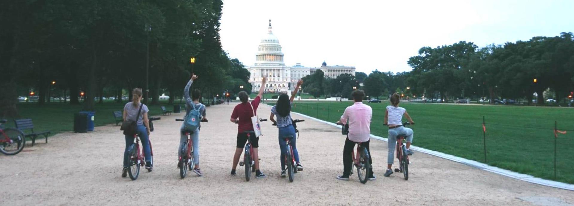 Six people on bikes at the National Mall with the Capitol Building in the background
