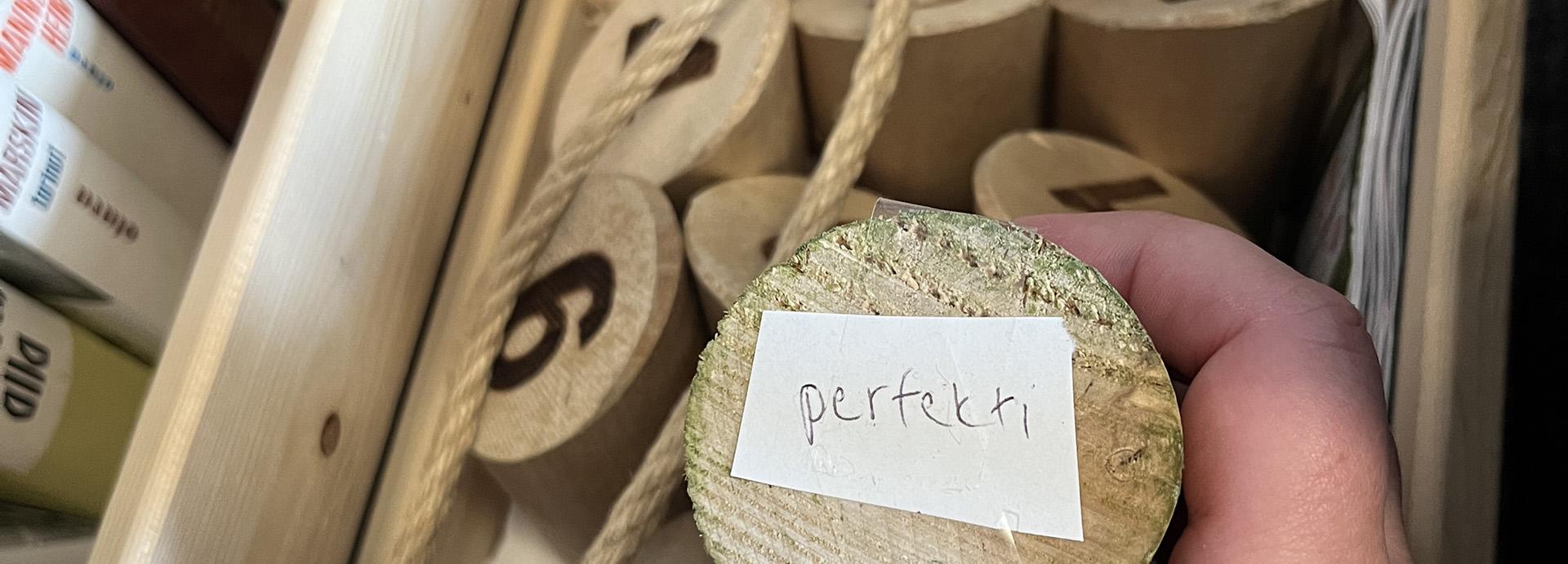 Mölkky pin with a word "perfekti" on it, a part of an escape room game requiring Finnish language skills