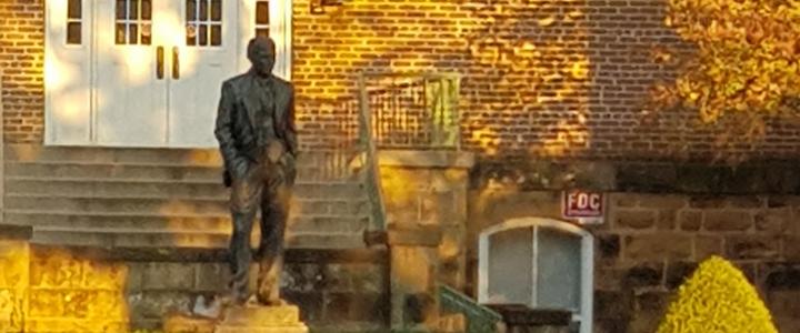 The statue of J. William Fulbright at the University of Arkansas campus on a sunny autumn day