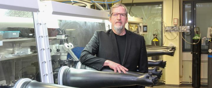 Fulbright-Nokia Distinguished Chair in Information and Communications Technologies in a laboratory, standing among long and black glove-like items.