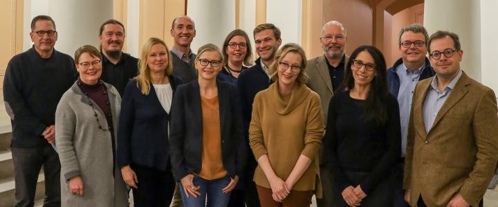 Leading scholars from Finland, the United States, the United Kingdom, and Germany in a group photo taken at the lobby of the main building of the University of Helsinki.