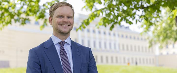 Photo of Jukka Välimaa taken in front of the Ministry for Foreign Affairs Merikasarmi building on a sunny summer day.