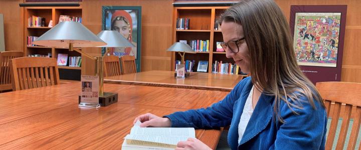 Mervi Kaukko reading a book in a library