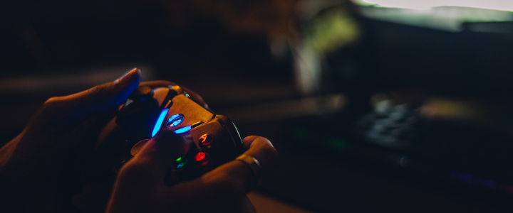 A person holding a game controller in a dark room