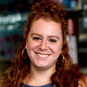 Person with curly red hair smiling