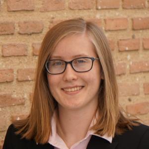 A person wearing glasses and a black jacket