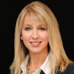 A person with blonde hair smiling