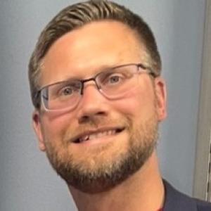 A person with glasses smiling