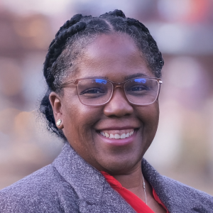 A person wearing glasses and a grey jacket